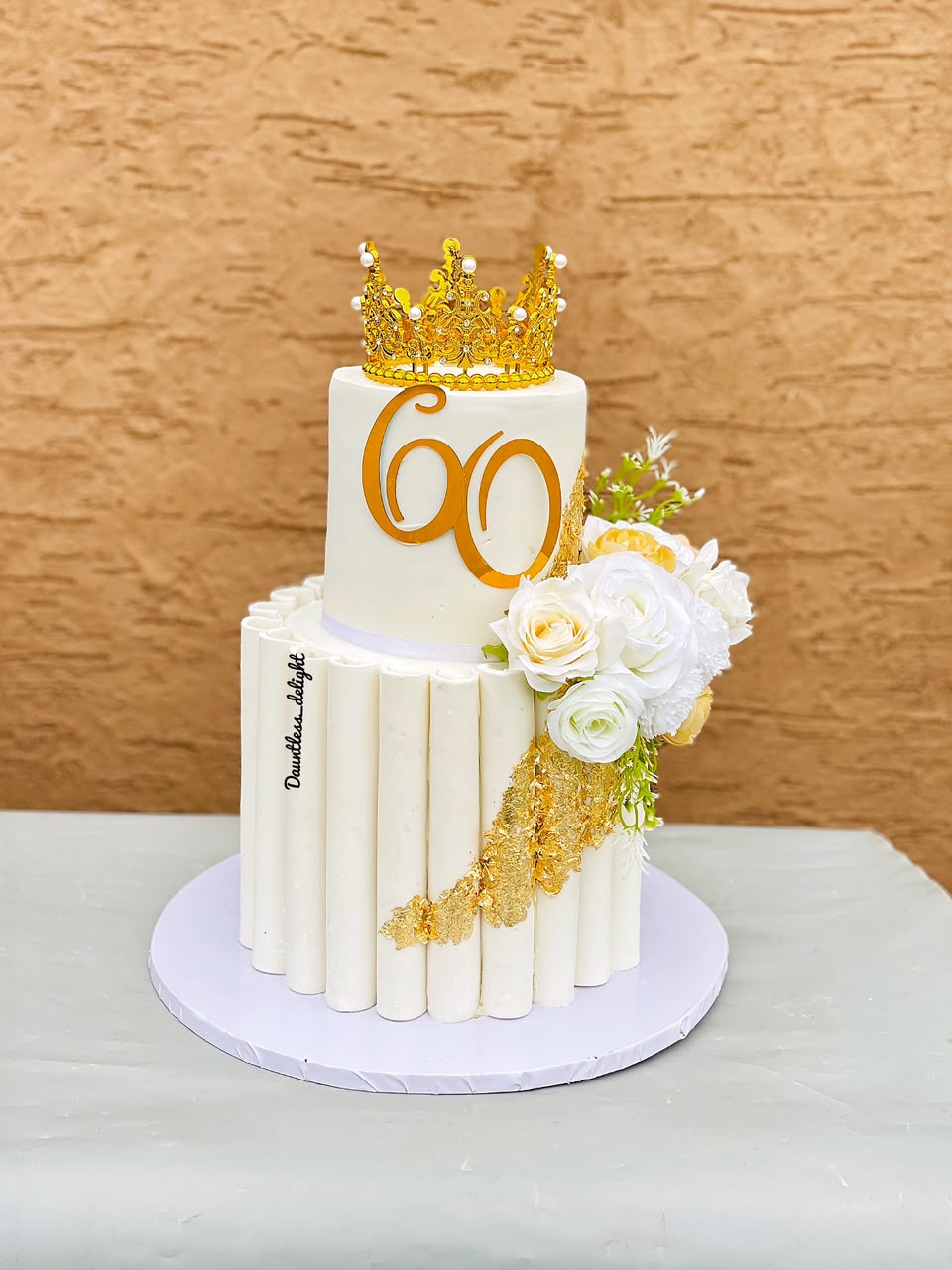 White and gold 60th milestone cake with crown topper and sugar roses