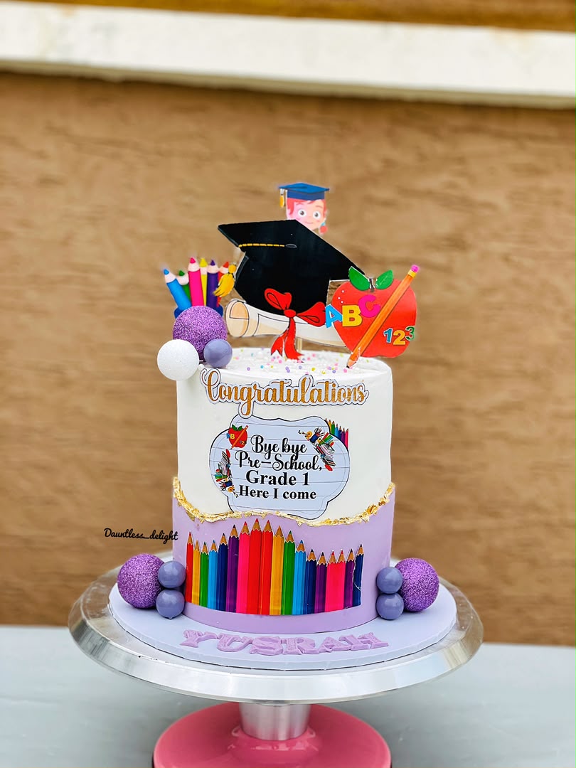 Two tier graduation cake with pencils, congratulations topper