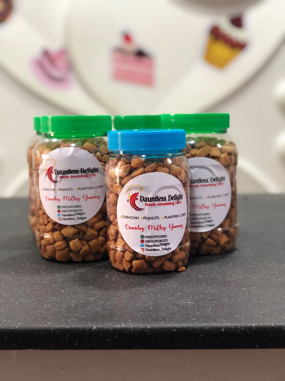 Branded jars of Dauntless Delight chin chin, peanuts and plantain chips
